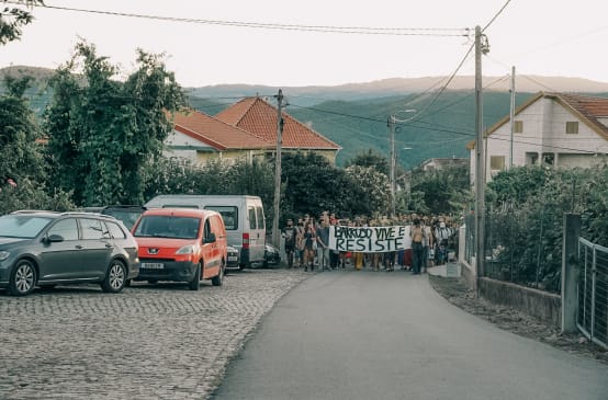 Participantes do Acampamento em Defesa do Barroso, em Covas do Barroso, Portugal, se manifestam pelos passeios da aldeia com uma faixa na qual se lê "Barroso vive e resiste"