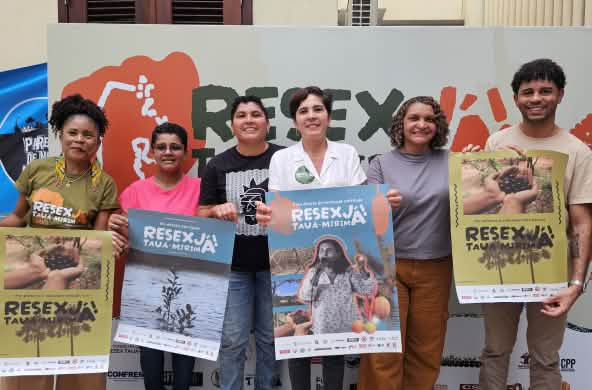 Grupo de seis pessoas seguram cartazes em apoio à Resex Tauá-Mirim