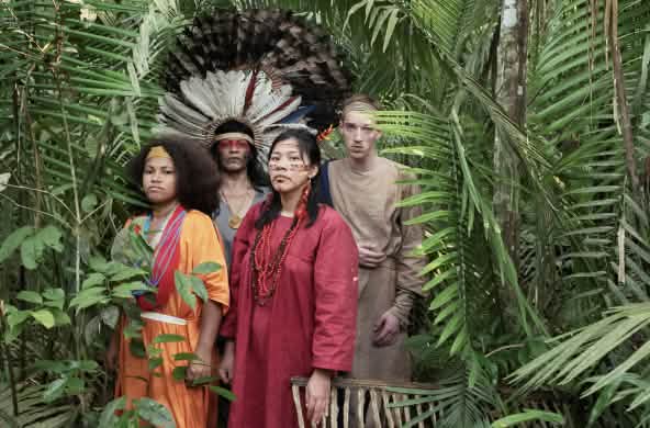 Atrizes e atores da peça de teatro “Antígona na Amazônia” em pé, na floresta amazônica