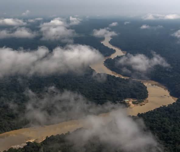 Fotografia aérea com nuvens e rio sinuoso passando pela floresta tropical
