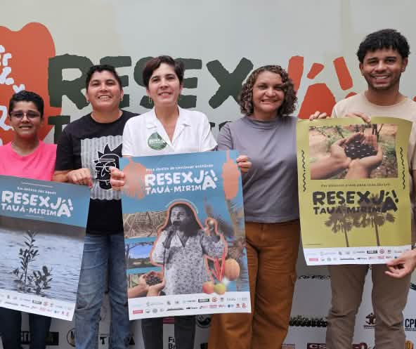 Grupo de seis pessoas seguram cartazes em apoio à Resex Tauá-Mirim