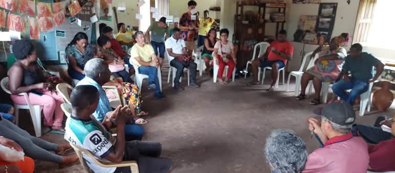 Intercâmbio contra o projeto porto-ferroviário da GPM em Alcântara, Maranhão, no início de abril de 2024 Um grupo de pessoas se senta em círculo em cadeiras de plástico em uma sala
