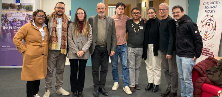 Foto de grupo de 9 pessoas à frente da entrada de um escritório da Comissão Européia l