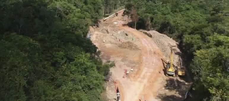 Foto área das obras de construção do mineroduto para transporte de bauxita na floresta equatorial, com escavadeiras contendo terra revirada e pedaços dos tubos