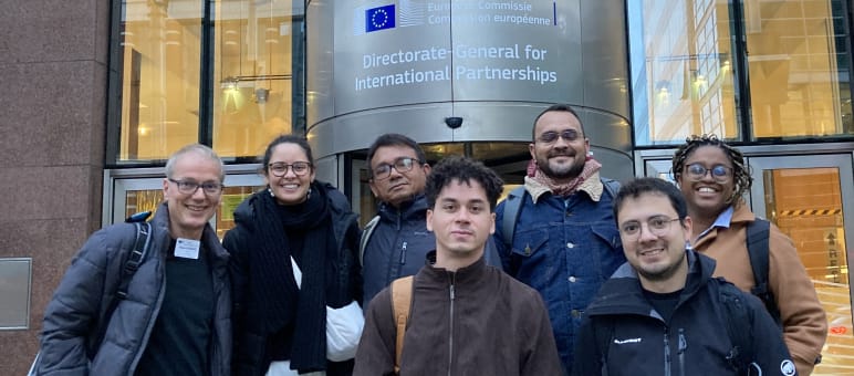 Foto de grupo de 7 pessoas à frente da entrada de um prédio da Comissão Européia em Bruxelas l