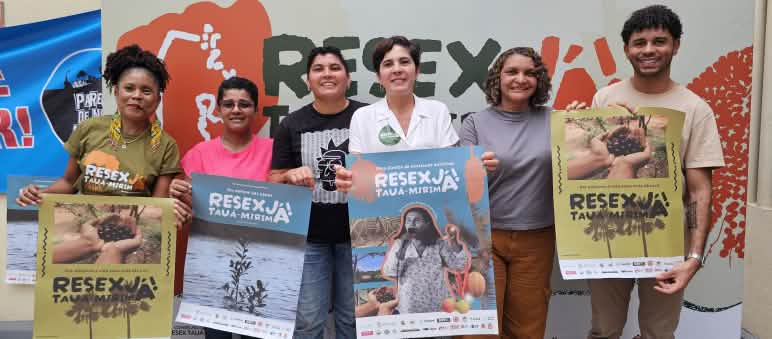 Grupo de seis pessoas seguram cartazes em apoio à Resex Tauá-Mirim