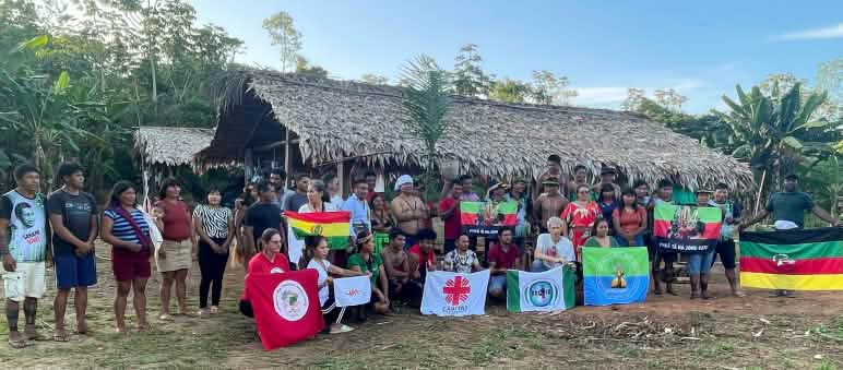 Grupo no território indígena Ka'apor, diante de uma casa