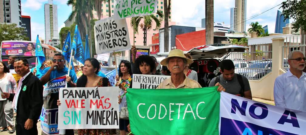 Pessoas com placas feitas à mão protestando contra a mineração na Cidade do Panamá