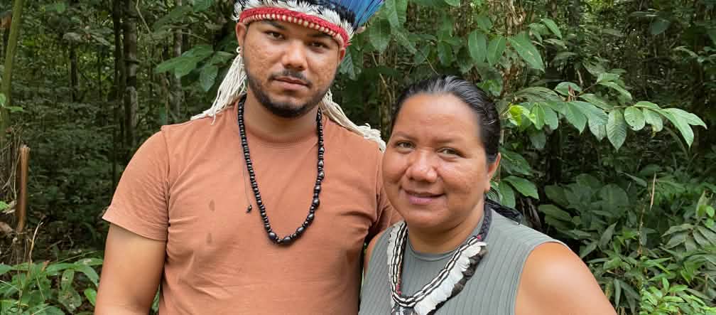 Retrato de uma mulher indígena com um colar de penas à direita e de um jovem indígena com uma coroa de penas à esquerda
