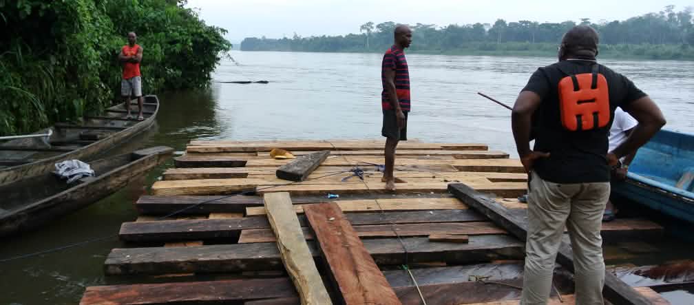 Odey Oyama (de colete salva-vidas) em jangada de desmatadores