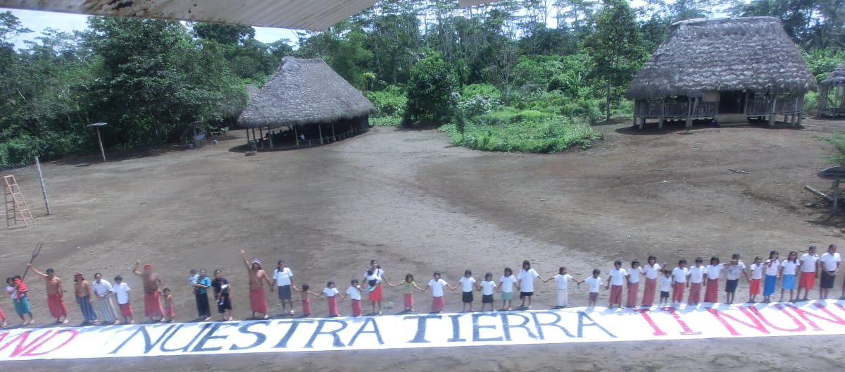 Nossa terra - nuestra tierra! Corrente humana com faixas contra o roubo de terras no Equador