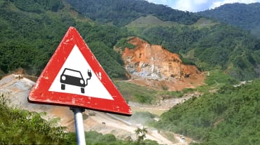 (Montagem de foto) Placa de trânsito com carro elétrico em frente de uma mina de lavra a céu aberto