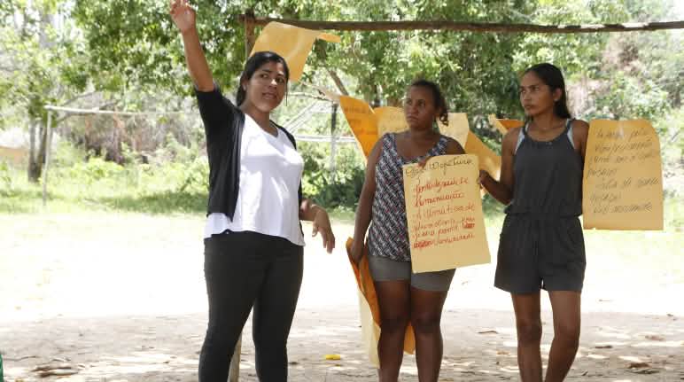 Três participantes de um workshop do Movimento Xingu Vivo para Sempre seguram pôsteres
