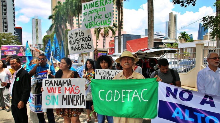 Pessoas com placas feitas à mão protestando contra a mineração na Cidade do Panamá