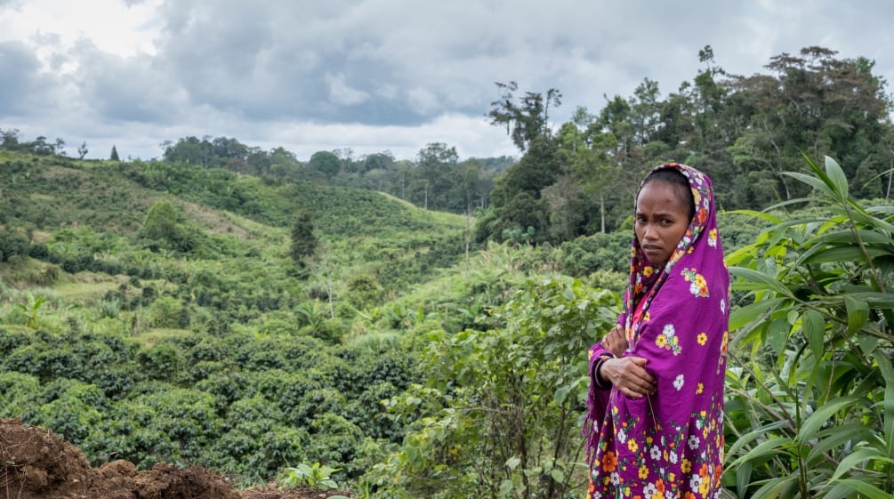 Mirivic Tarsila Danyan, coberta por um véu, em frente de área de floresta desmatada nas Filipinas