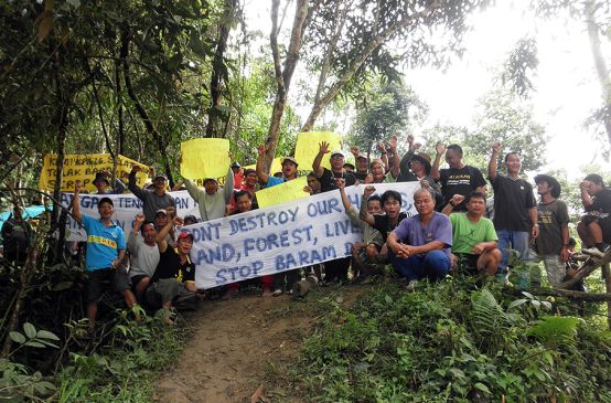 Indígenas protestam contra a barragem de Baram com estandartes na floresta tropical de Sarawak
