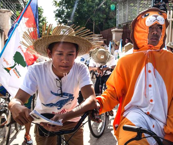 Manifestantes em fantasias de animais em bicicletas no Camboja