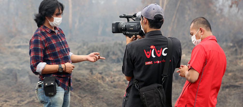 “Mil hectares de floresta de turfa foram queimados aqui”, diz o ativista Feri Irawan numa entrevista na televisão. “Mas ainda podemos salvar a maior parte da floresta.” Um homem está sendo entrevistado à frente de uma floresta tropical em chamas