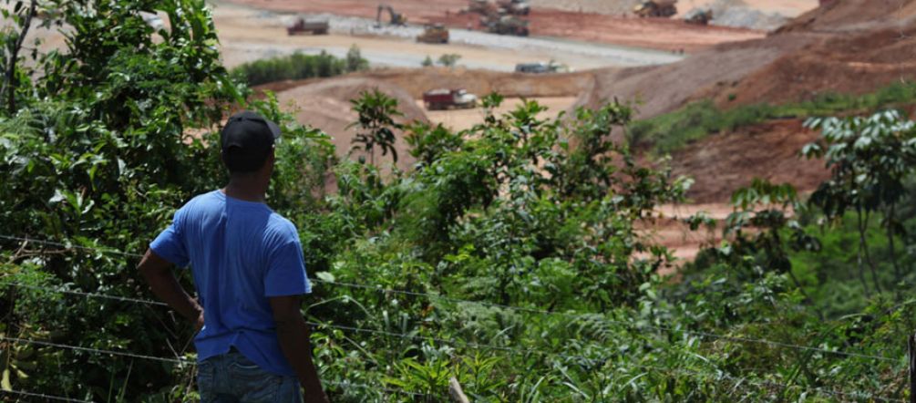 Olhar perplexo à destruição Agricultor está na floresta e olha para uma mina aberta