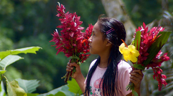 Uma garota do povo Kichwa em Sarayaku com flores nas mãos